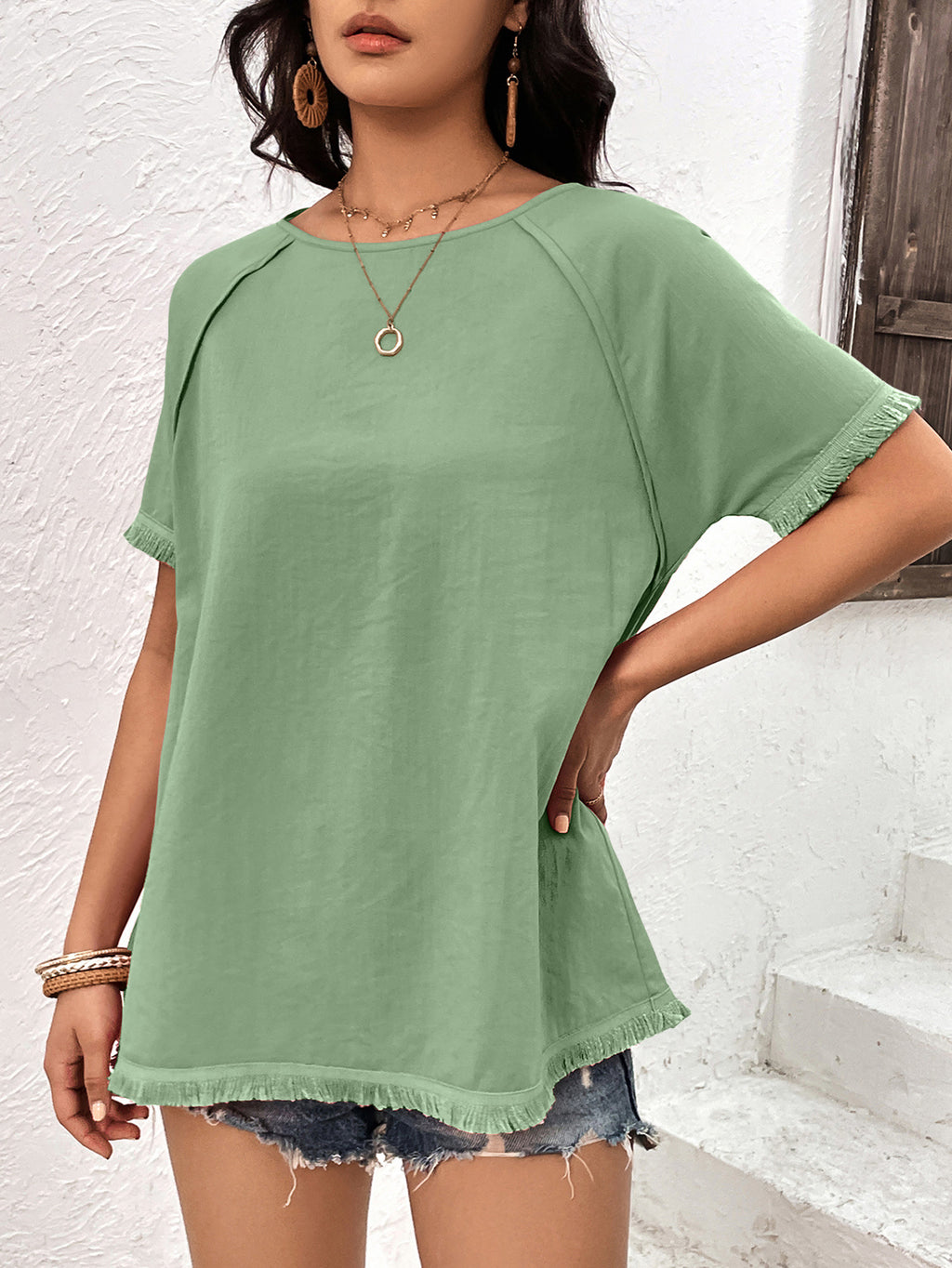 Light green fringe trim raglan sleeve top side view on model
