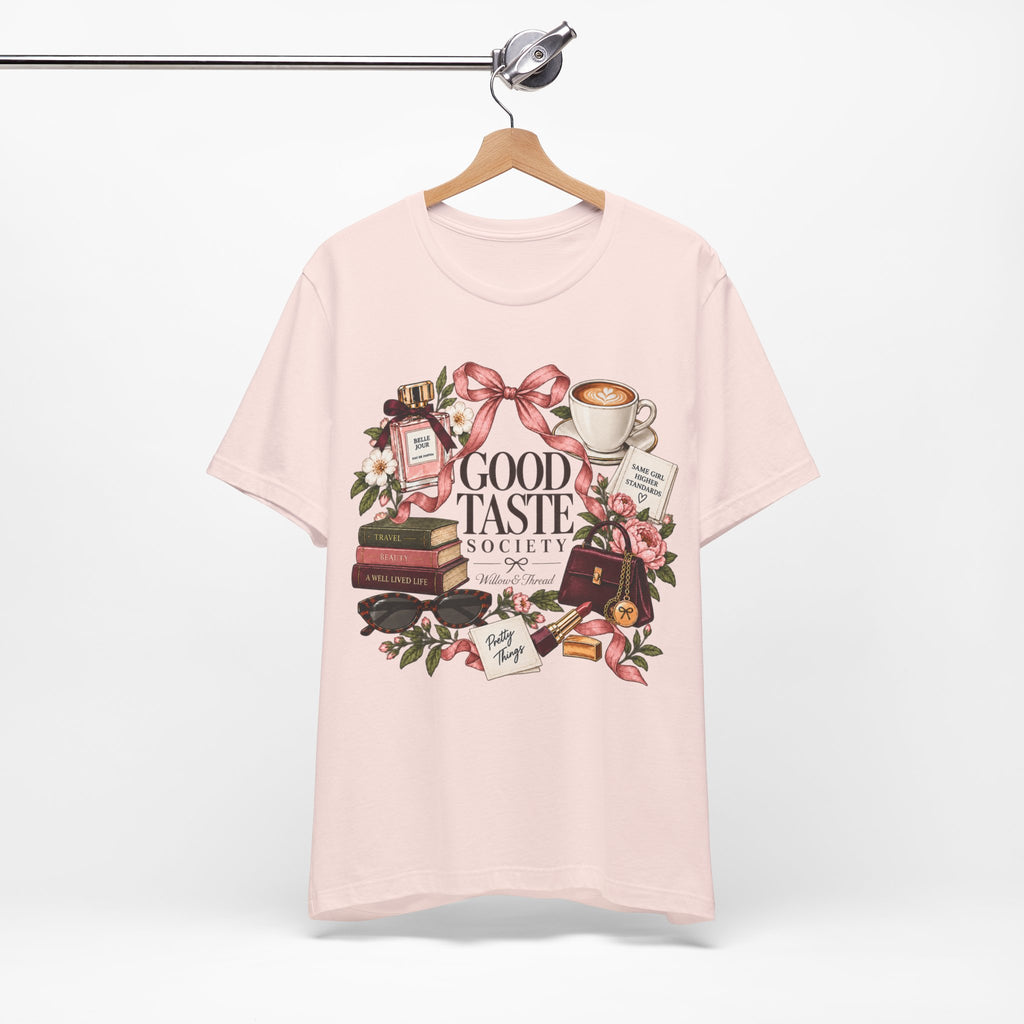 Good Taste Society feminine graphic tee featuring coffee, books, pink bows, flowers and boutique accessories