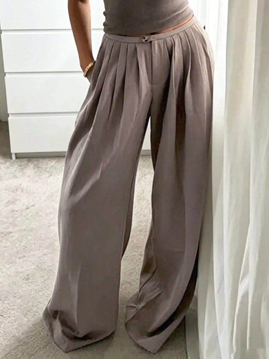 Khaki pleated pants with a relaxed wide-leg silhouette