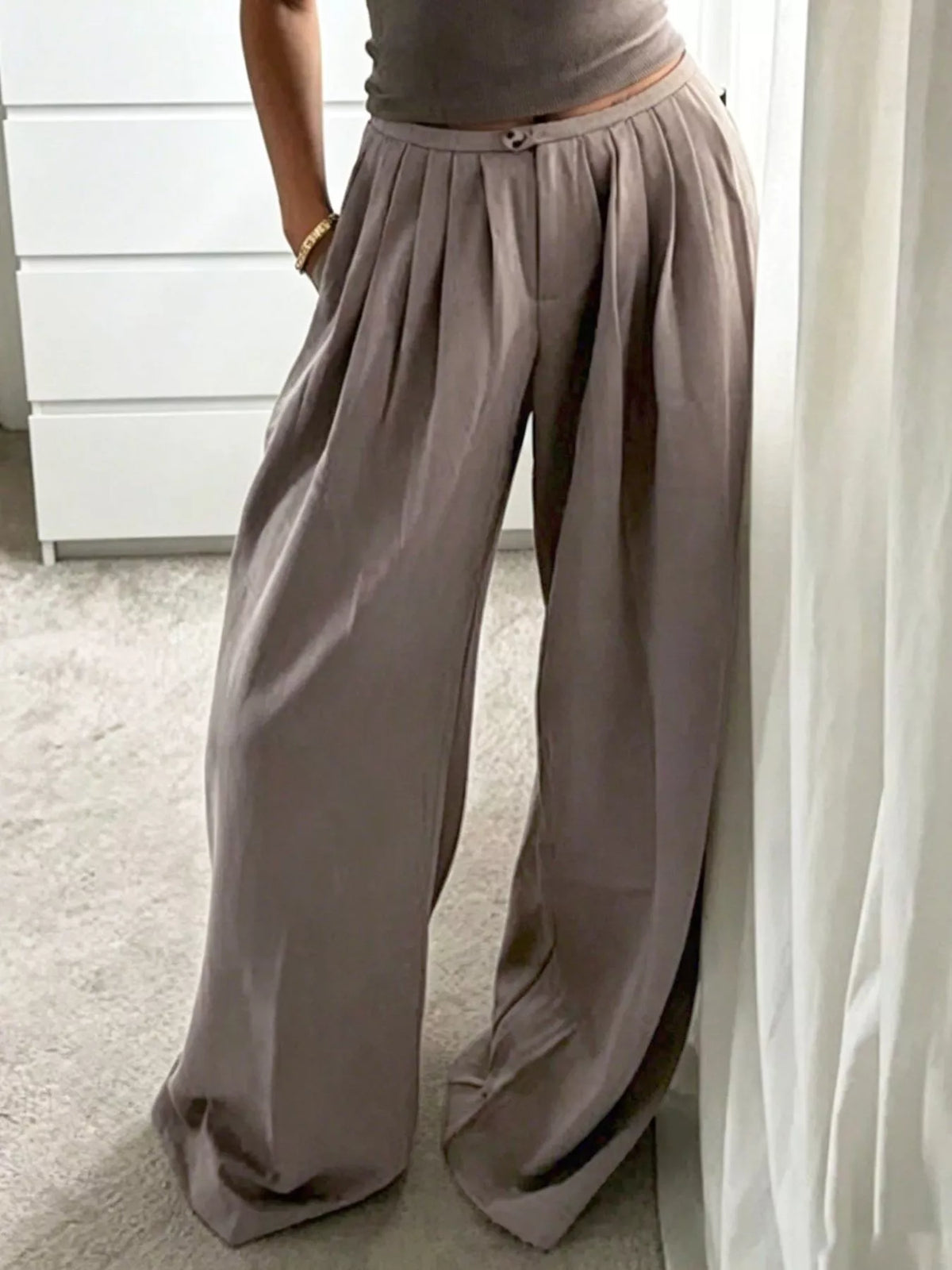 Khaki pleated pants with a relaxed wide-leg silhouette