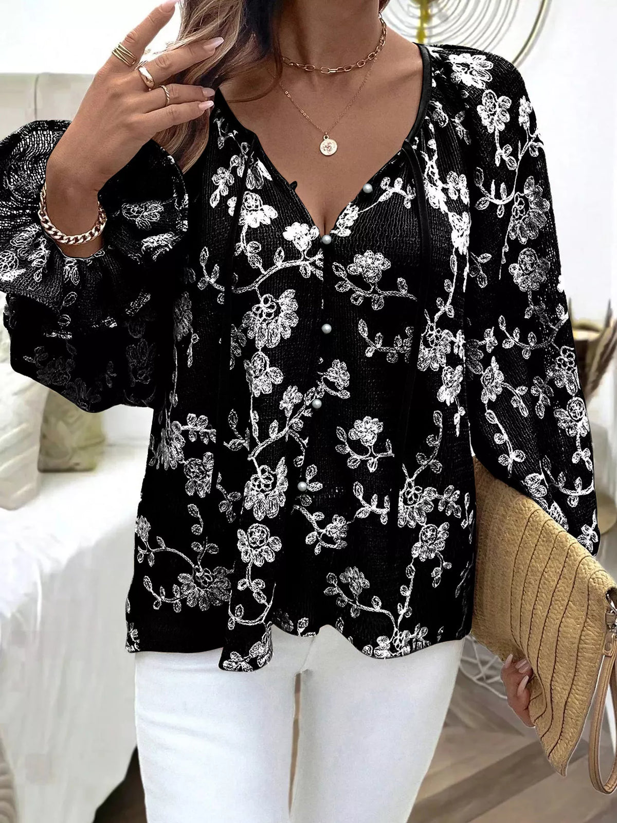 Black floral embroidered blouse with long sleeves and ruffle details
