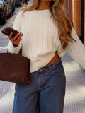 Women’s cream cable knit crew neck sweater styled with blue jeans
